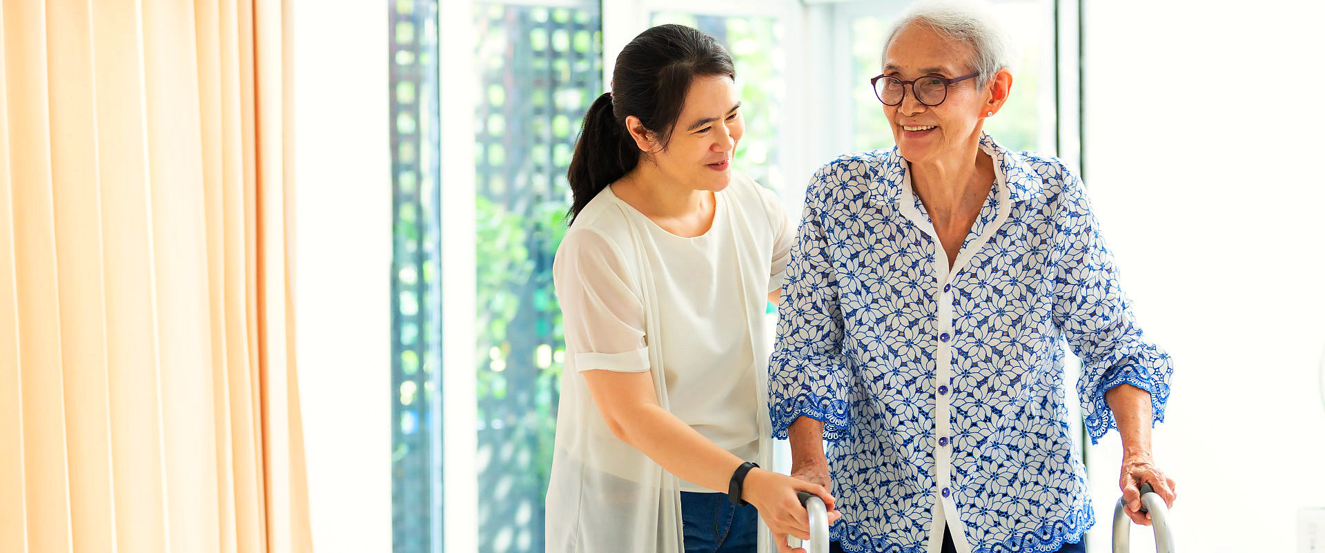 a female caregiver assisting an elderly woman